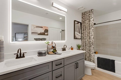A bathroom with a white countertop and a grey cabinet.