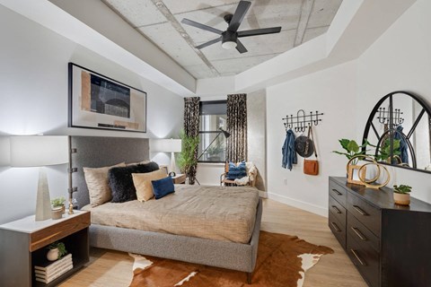 A bedroom with a bed, a dresser, and a mirror.