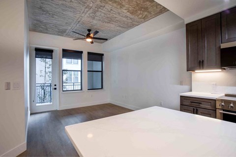 A kitchen with a white countertop and wooden cabinets.