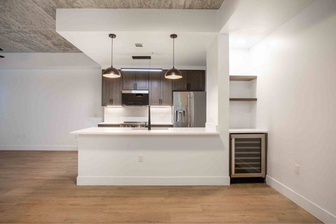 A kitchen with a white island and a refrigerator.