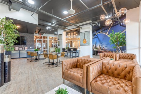 A room with brown leather couches and a wooden floor.