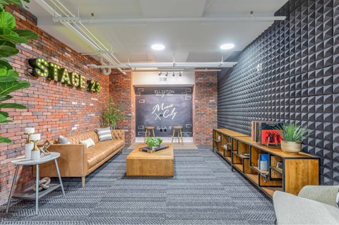 A modern living room with a brick wall and a stage 12 sign.