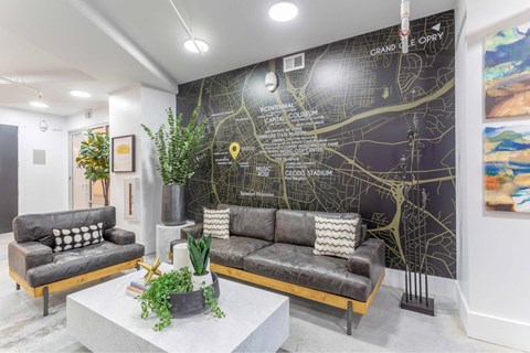 A living room with a grey sofa and a map on the wall.