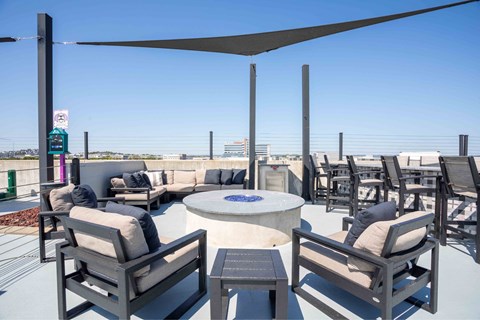 A patio with a table and chairs under a shade sail.