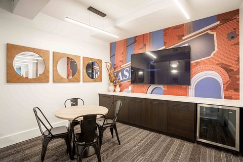 A conference room with a table, chairs and a mural on the wall.