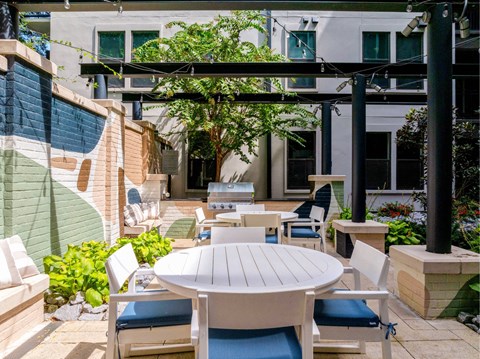 A patio with a table and chairs under a pergola.