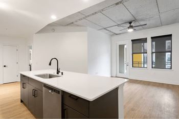 A modern kitchen with a white countertop and dark brown cabinets.