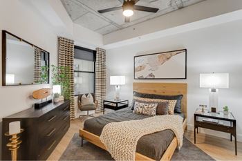 A bedroom with a large bed and a ceiling fan.