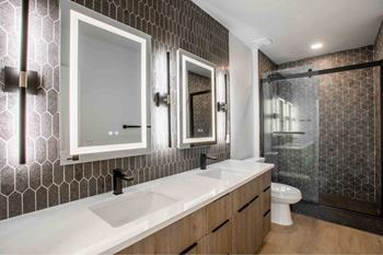 A modern bathroom with a white sink and a glass shower.
