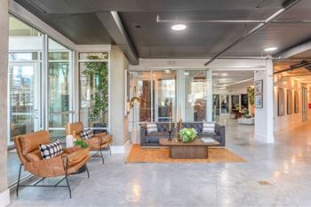 A modern living room with a large window and a grey floor.