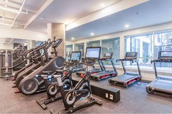 A gym with treadmills, elliptical machines, and other exercise equipment.