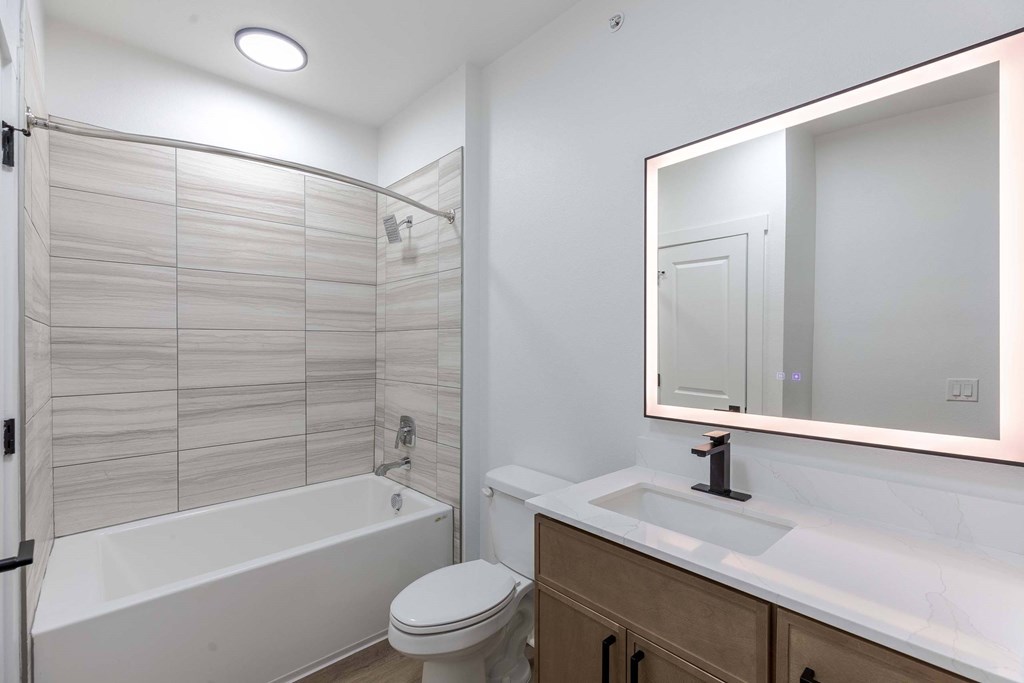 A white bathroom with a toilet, sink, and bathtub.