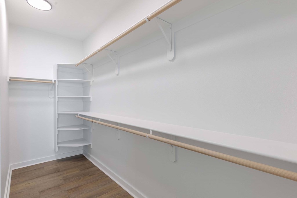 A white refrigerator with a wooden shelf below it.