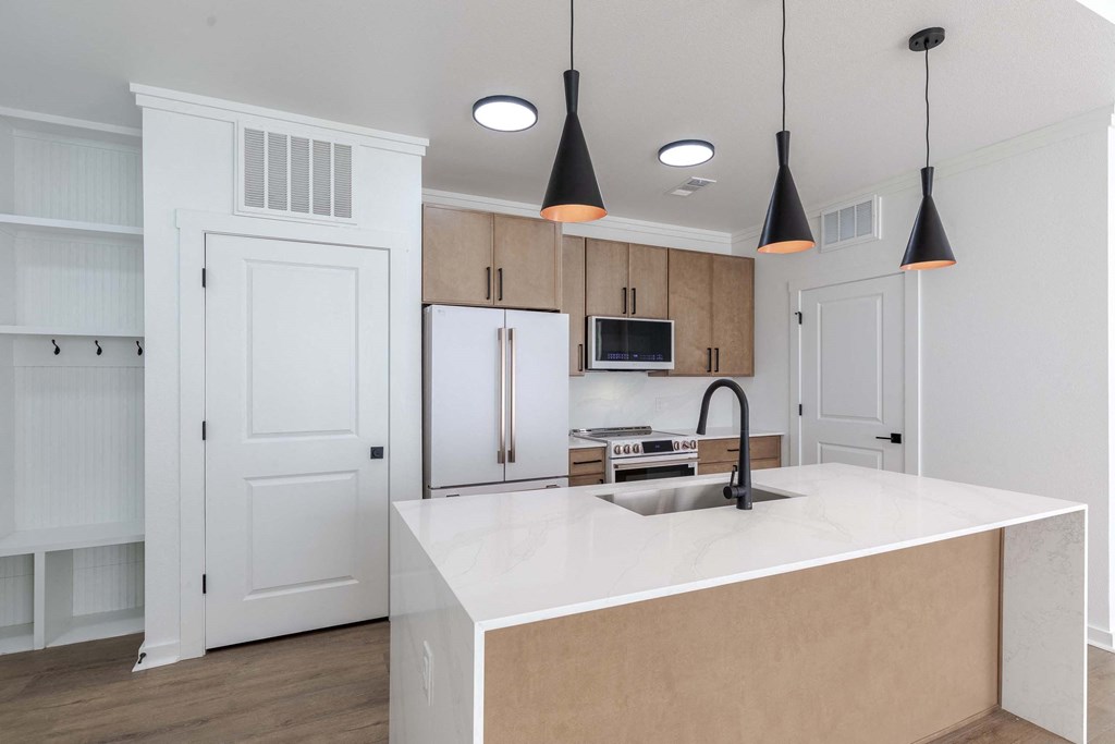 A kitchen with a white countertop and a sink.