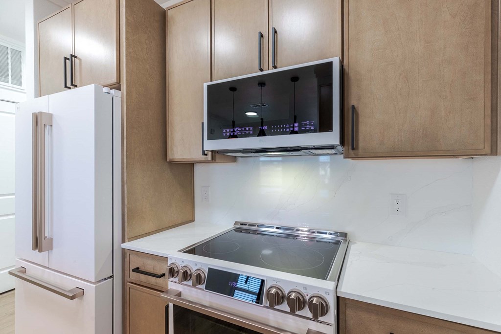 A modern kitchen with a stainless steel stove and a white refrigerator.