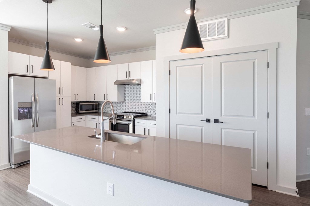 A kitchen with a white counter and cabinets.