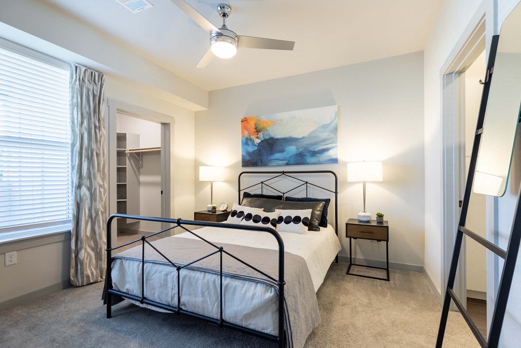 A bedroom with a large bed and a ceiling fan.