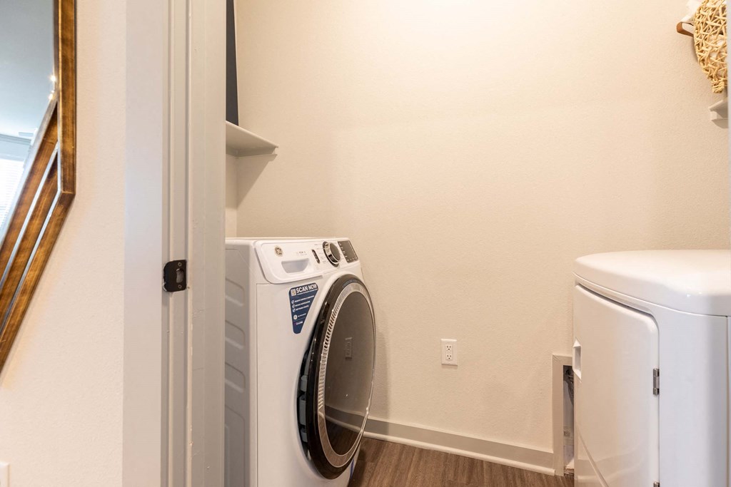 A white washing machine is in a laundry room.