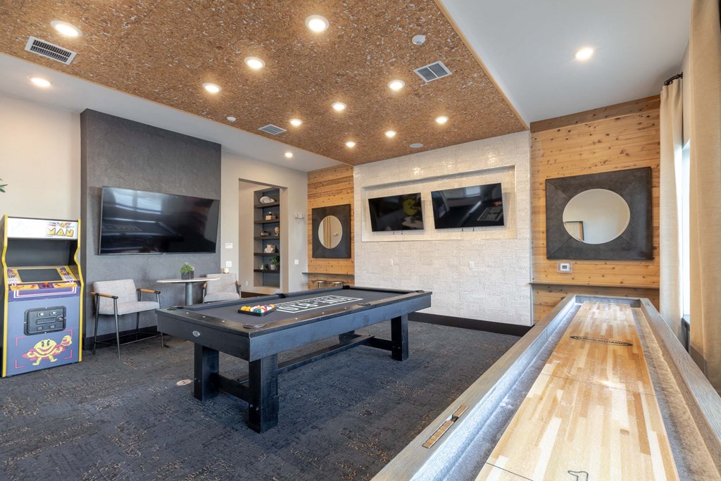A room with a pool table and a foosball table.