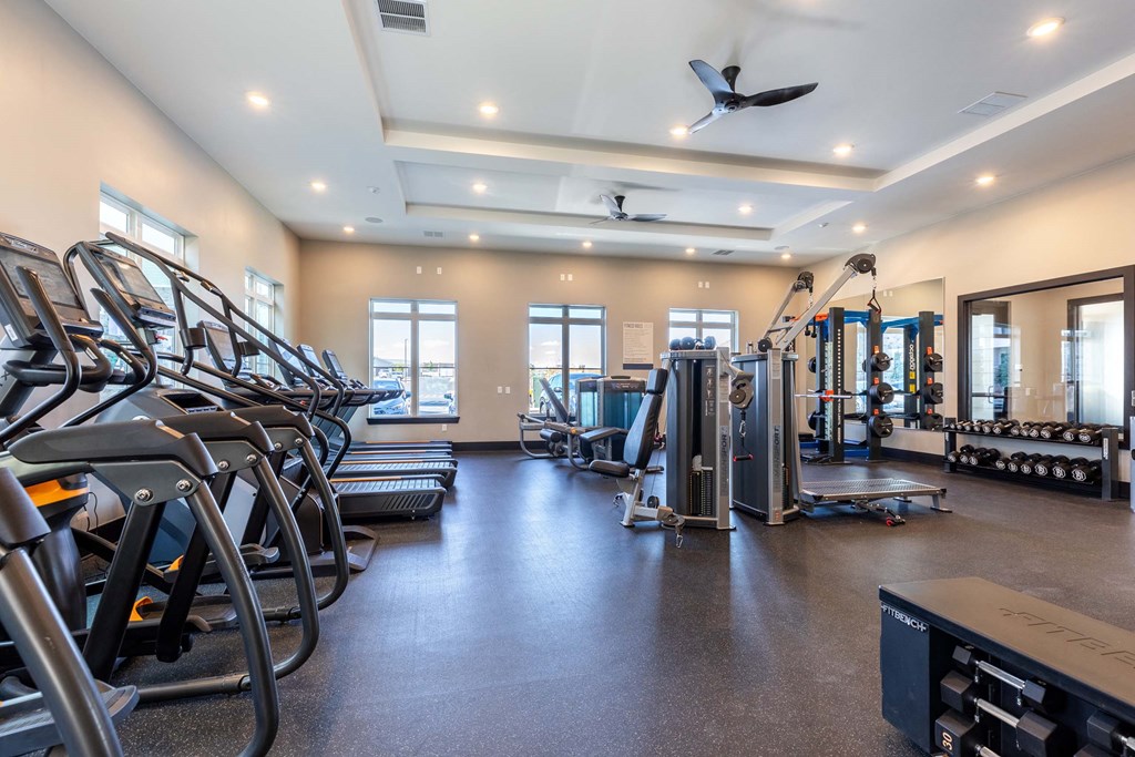 A spacious gym with treadmills, elliptical machines, and other exercise equipment.