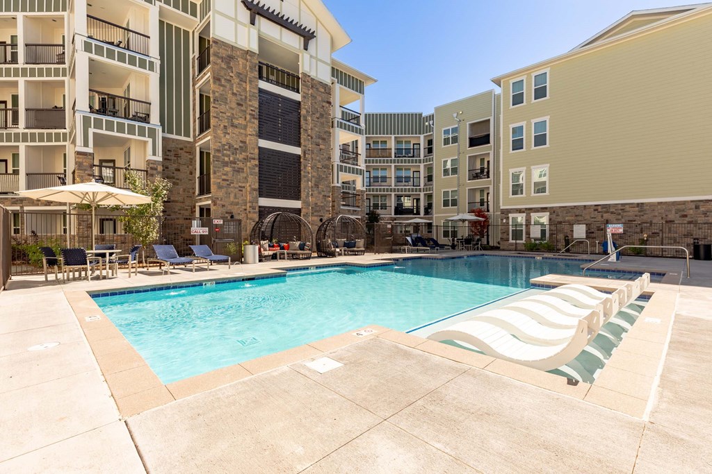A large swimming pool surrounded by apartment buildings.