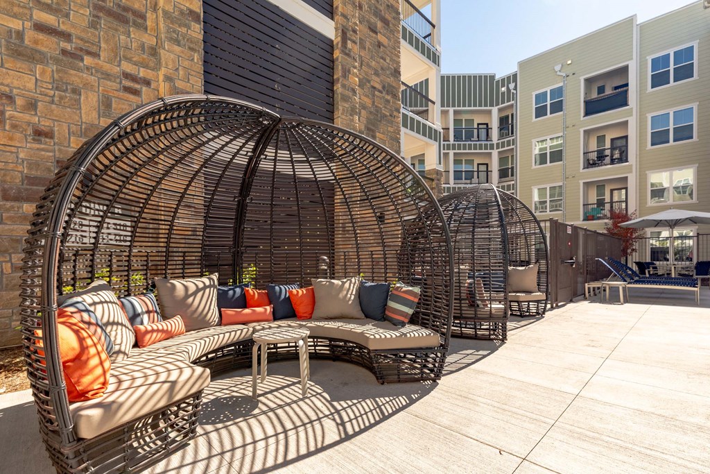 A large outdoor patio with a circular woven metal structure and a couch.