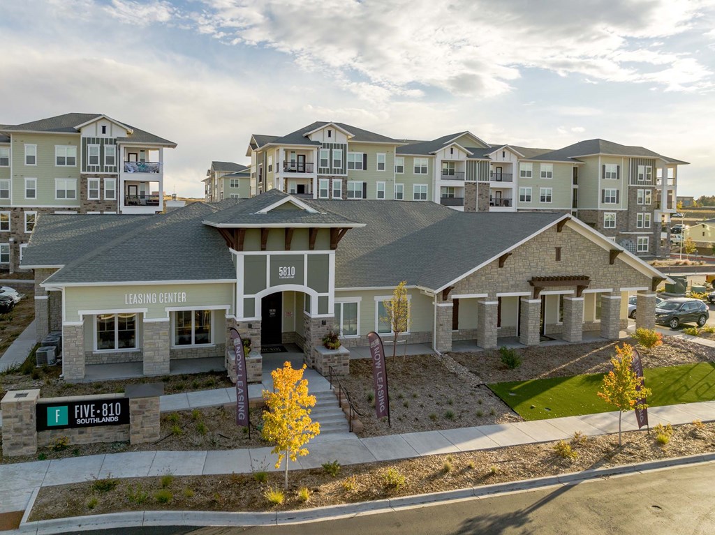 A leasing center for apartment buildings is located in a parking lot.