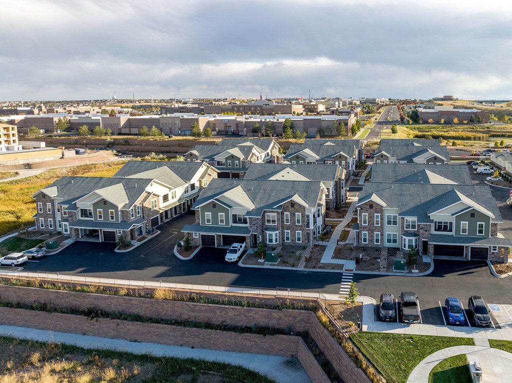 A large, modern residential complex with multiple houses and a parking lot.