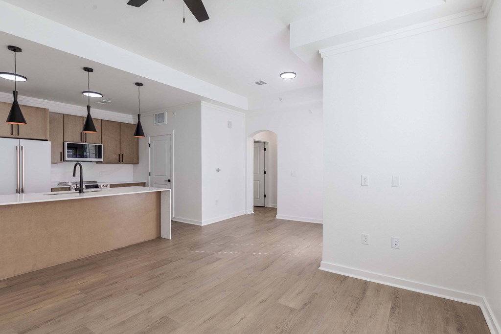 A kitchen with a refrigerator, microwave, and oven.