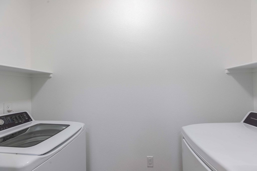 A white washing machine and dryer in a small laundry room.