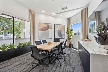 A conference room with a long table and chairs.