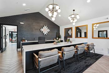 A modern kitchen with a long island and chairs.