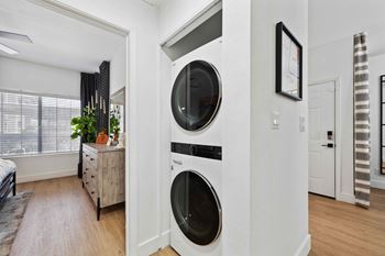 A modern laundry room with a washer and dryer built into the wall.