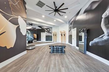 A room with a large mural on the wall and a ceiling fan.