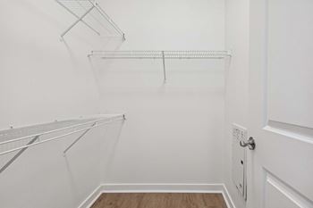 A white closet with a door and shelves.