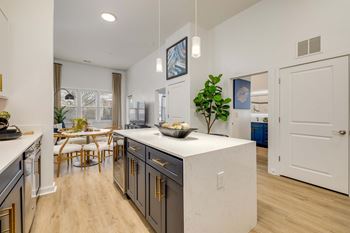 A kitchen with a white island and wooden floors.
