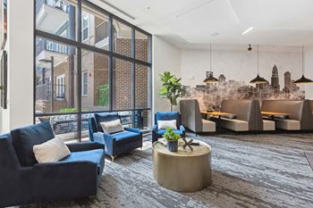 A living room with blue couches and a large window.