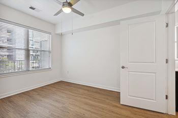A room with a ceiling fan and a door.