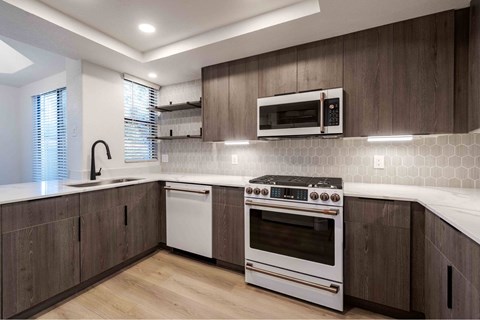 A modern kitchen with a white oven and microwave above it.