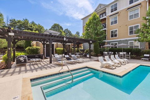 A large outdoor swimming pool with a slide and sun loungers.