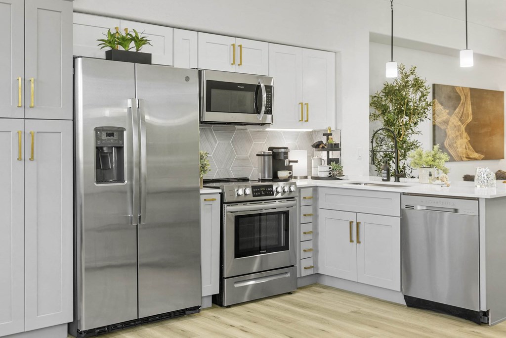 A modern kitchen with a stainless steel refrigerator and oven.