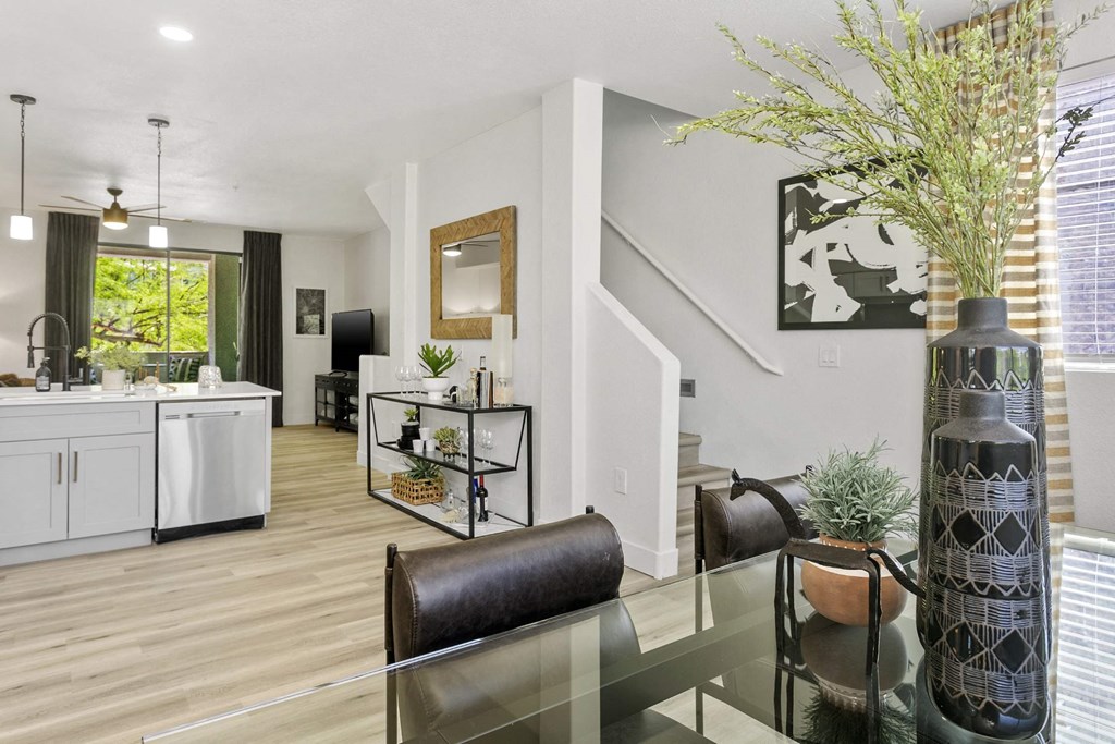 A modern kitchen with a glass table and a black chair.