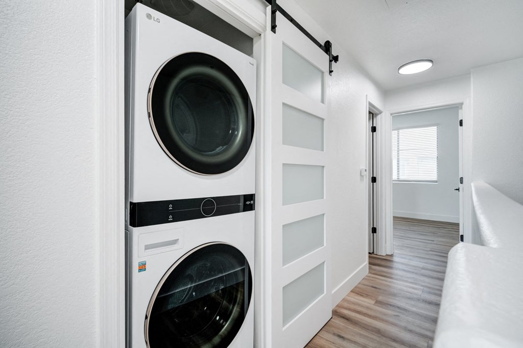 A white LG washing machine and dryer in a small laundry room.