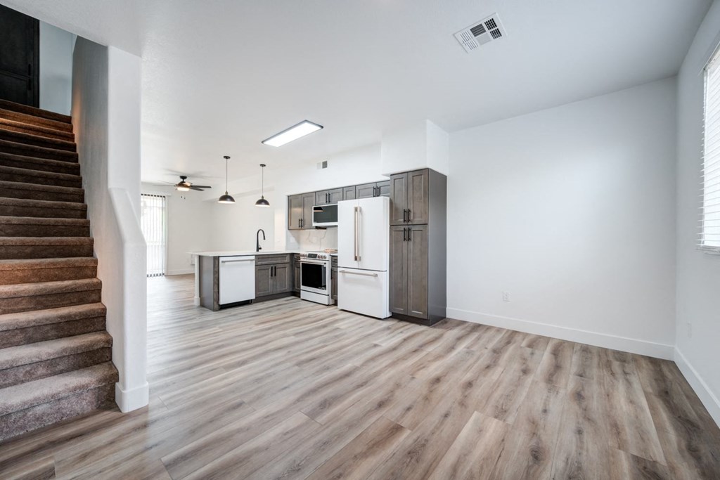 A kitchen with a refrigerator, oven, and microwave is shown.