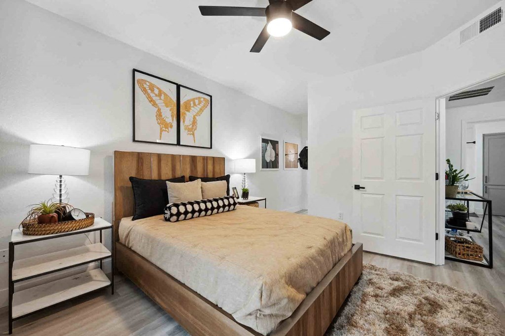 A bedroom with a bed, a ceiling fan, and a rug.