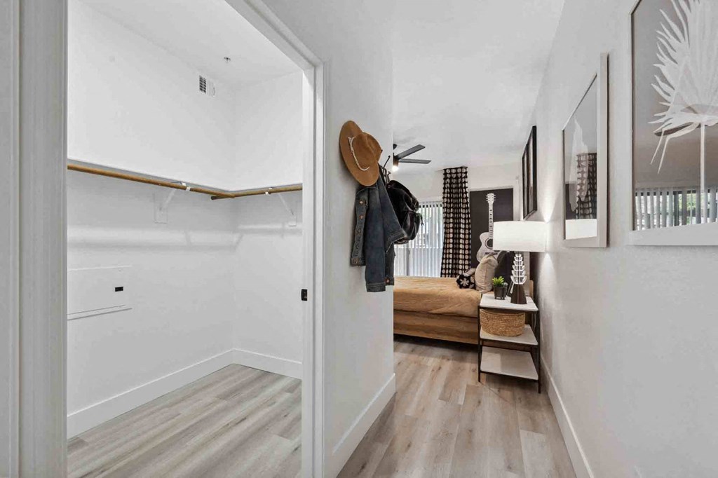 A hallway with a bench and a coat rack.