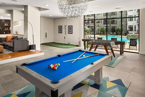 A pool table in a room with a view of the city.