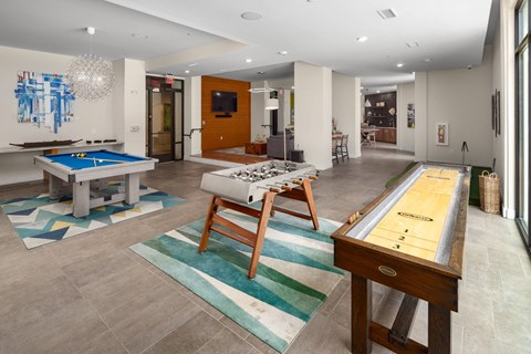 A room with a pool table and a shuffleboard table.