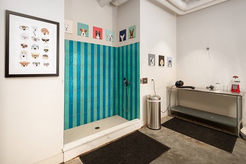 A bathroom with a blue tiled shower and a sink.