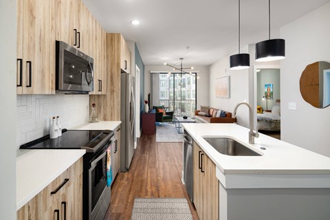 A modern kitchen with wooden cabinets and a black countertop.